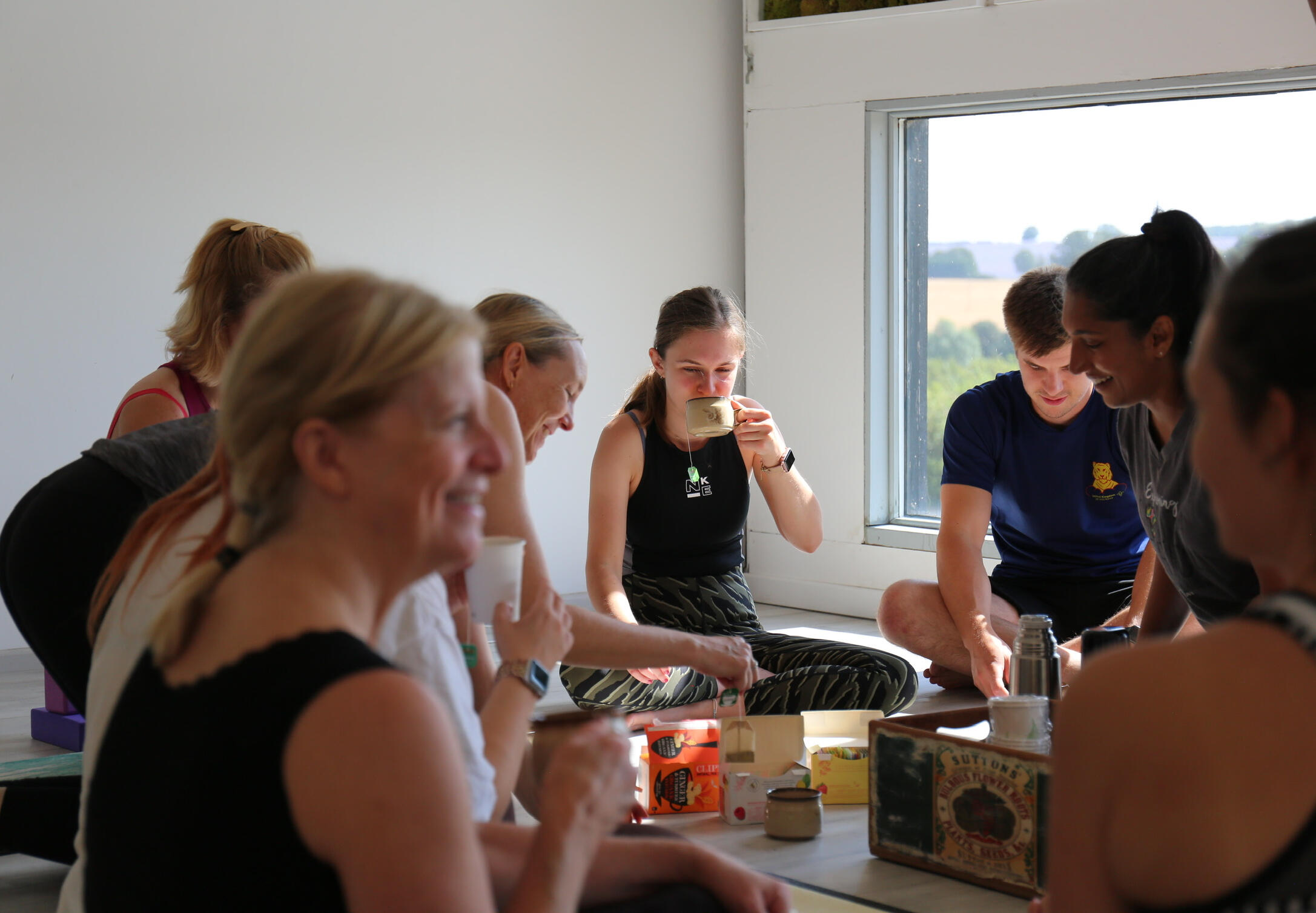 Community members sharing tea and conversation after class at Thaxted Wellness Hub, Essex